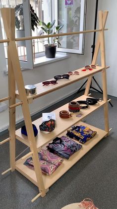 a wooden shelf with sunglasses on it in front of a window