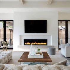 a living room filled with furniture and a flat screen tv mounted on the wall above a fire place