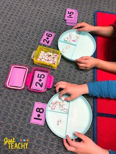 two children are playing with their numbers and placemats on the floor in front of them