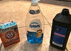 two bottles of dawn and baking soda sit next to each other on the floor in front of a box