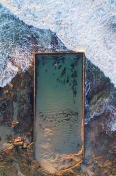 an aerial view of the ocean and sand