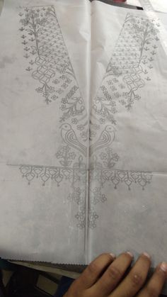 two sheets of paper with designs on them, one being folded up and the other is laying down