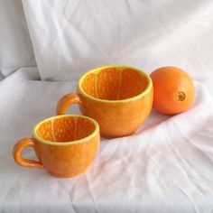 two oranges sitting next to each other on a bed