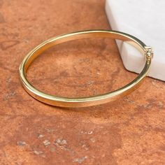 18KT yellow gold 4mm wide, polished-finish, oval, flat, hinged bangle bracelet. The perfect, everyday bangle bracelet in high quality 18k gold! Width: 4mm Length around inside: 6.75" Inside diameter: 2.375" Shown on a 6" wrist Width: 6mm Weight: 10.89 grams High end + designer piece Hallmarked / Stamped 18KT Solid 18k Hollow bangle Oval in shape Hinged and figure 8 latch Made in Italy Solid Gold Bangle, Saint Jewelry, Pearl Accessories, Figure 8, White Gold Necklaces, White Gold Earrings, Yellow Gold Bracelet, Yellow Gold Pendants, Yellow Gold Earring