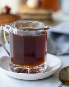 a glass pitcher filled with liquid sitting on top of a white plate