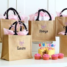 three bags that have cupcakes in front of them and one has a birthday cake on it