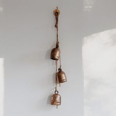 three bells hanging from a wall in a room