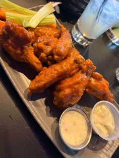 chicken wings, celery and carrots with ranch dressing on a white plate