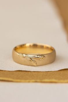 a gold wedding ring sitting on top of a napkin