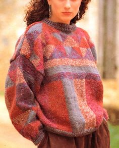 a young woman wearing a sweater and pants in the woods with her hands on her hips