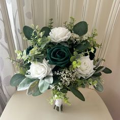 a bouquet of white and green flowers on a table