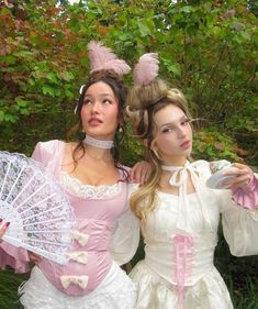 two women dressed in period costumes posing for the camera