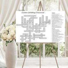 a crossword poster on a easel next to a vase with flowers in it