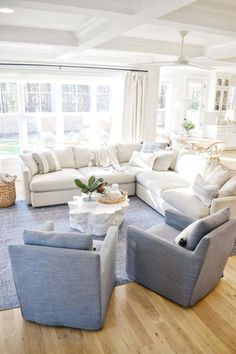 a living room filled with lots of furniture in it's centerpiece and windows