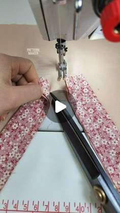 someone is using scissors to cut fabric on a sewing machine