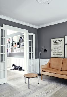 a living room filled with furniture and a dog laying on the floor next to it