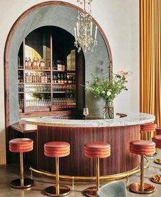 an old photo of a bar with stools and a chandelier hanging from the ceiling