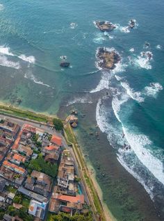 an aerial view of the ocean with houses and boats in the water near shore line