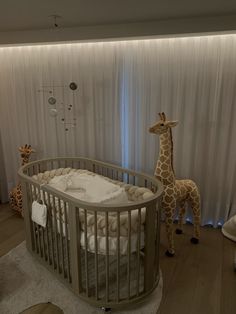 a giraffe standing next to a baby crib