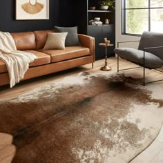 a living room filled with furniture and a brown rug on top of a hard wood floor