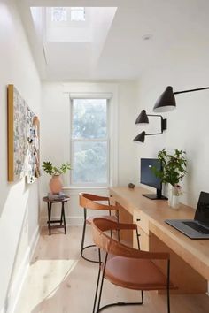 a long desk with chairs and a laptop on it