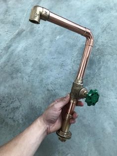 a person is holding a water faucet in their left hand, with the spigot attached to it