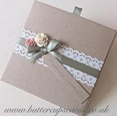 two wedding cards with lace and flowers on them, one is folded in brown paper