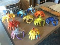 there are many different colored plastic crabs on the table