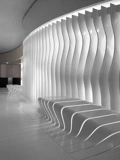 an empty room with white walls and curved benches