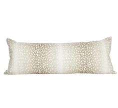 a white and beige pillow with an animal print pattern on the front, sitting on a white background