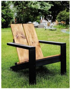 a wooden chair sitting on top of a lush green field