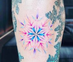 a colorful tattoo on the leg of a person's leg with an intricate design