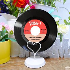 there is a record with a heart on it and flowers in the backround