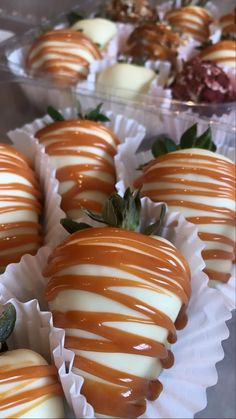 chocolate covered strawberries with white and brown glaze on them are lined up in plastic trays