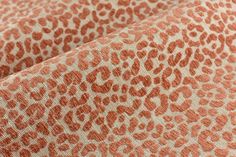 an orange and white animal print fabric with small spots on the top, in very close up