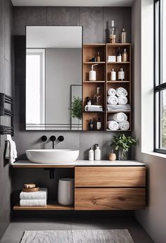 a bathroom with a sink, mirror and shelves filled with white towels on the floor