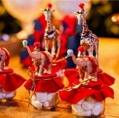 several small figurines sitting on top of candy in glass jars with giraffes