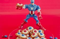 a plate with cookies and cupcakes in the shape of captain america