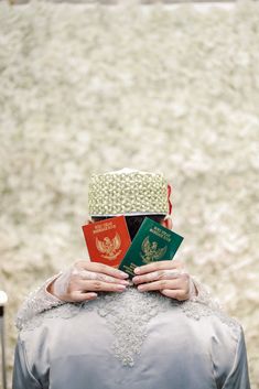 a woman with two passport's on her head, sitting in front of a field