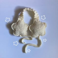 a crocheted white purse sitting on top of a blue surface with stars around it