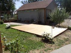 a backyard with a large wooden deck in the middle