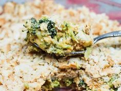 a spoon full of broccoli casserole on top of a red plate