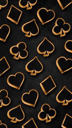 gold hearts and spades are arranged in the shape of heart shapes on a black background