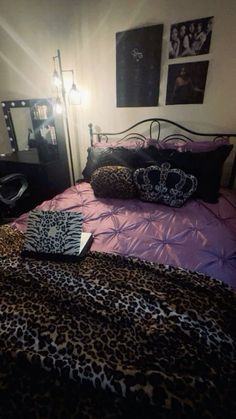 a leopard print comforter on a bed in a bedroom with pink sheets and pillows