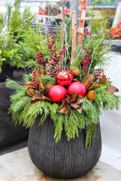 a potted planter with christmas decorations and pine cones on the top is shown