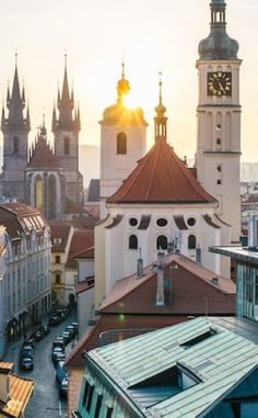 the sun shines brightly on an old city with tall buildings and steeples in the background