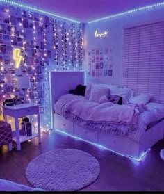 a bedroom decorated in purple and white with lights on the walls, bedding and rugs