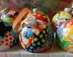 three colorful ornaments are sitting on a white shelf and one has a diamond in the middle