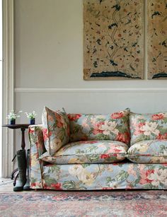 a living room with two paintings on the wall and a couch in front of it