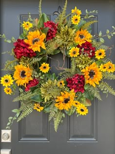 a wreath with sunflowers and greenery on the front door